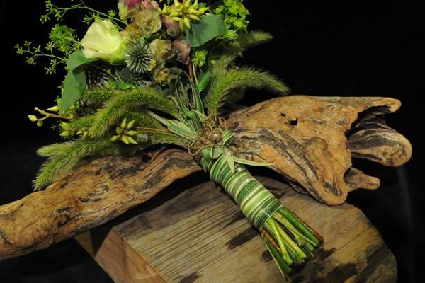 Field flowers, wheat, pods and grasses comprise this bridal bouquet for the wild at heart.