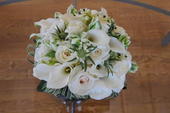 Scabiosa, roses, calla lilies and striped tropical leaves.