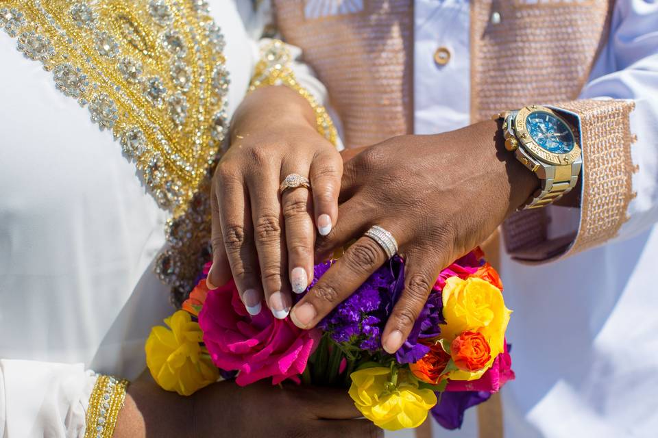 Couple with hands on bouquet