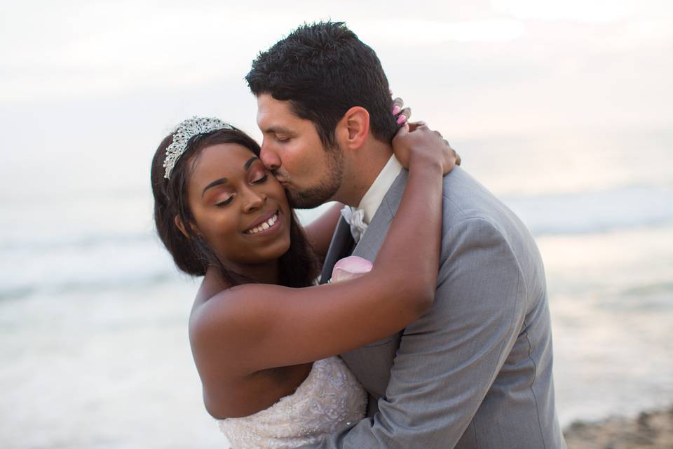 Groom kissin bride on cheek