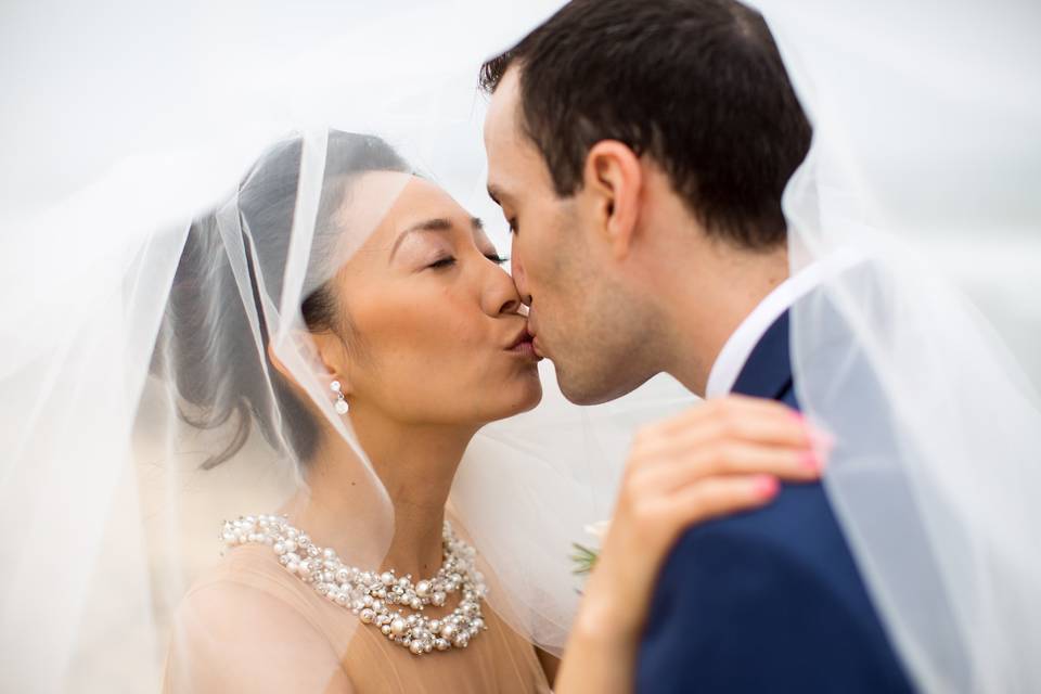 Couple kissing behind veil