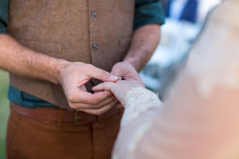 Groom putting ring on bride