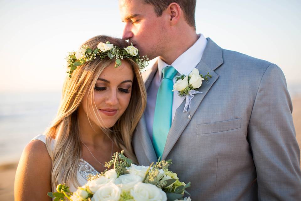 Groom kissing bride on head