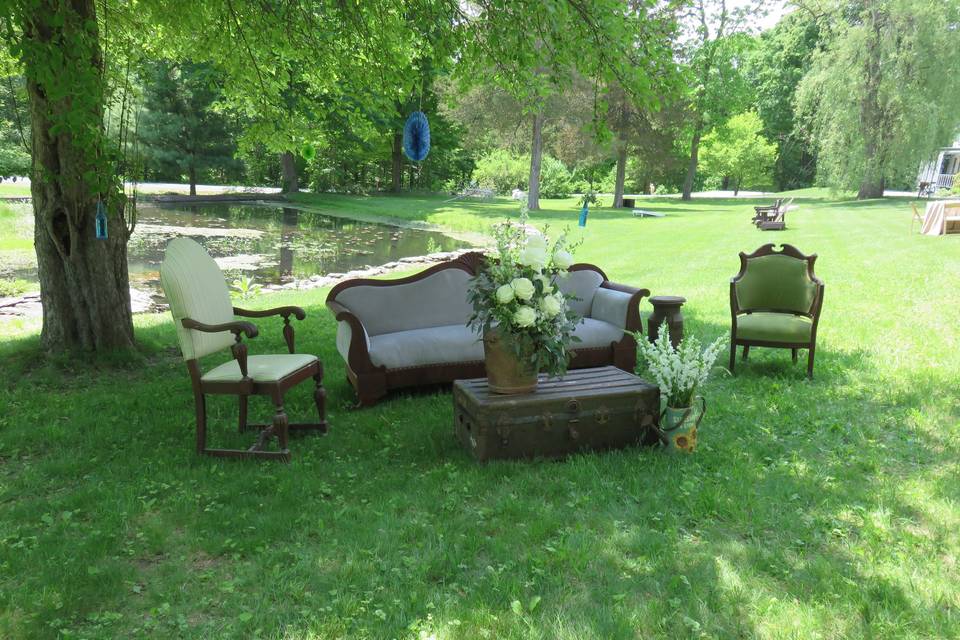 Vintage furniture set under the trees for cocktail hour.