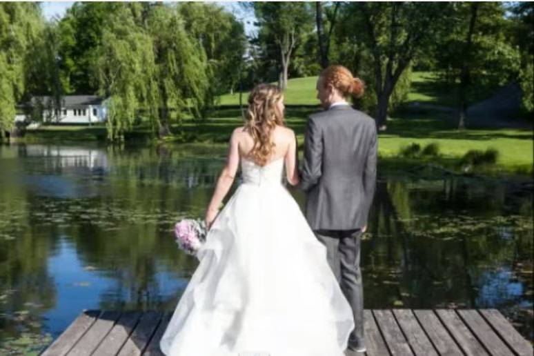 Bride and Groom on the dock of the pond.