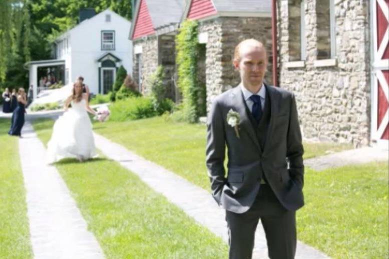 First Look.  Bride walking down the ribbon road toward her groom.