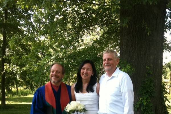 Bride and groom with their wedding officiant