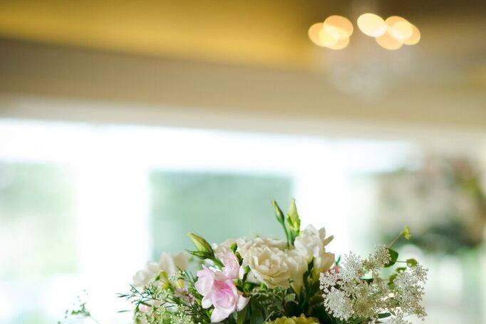 Gold candlestick with hydrangeas, roses and other wild flowers