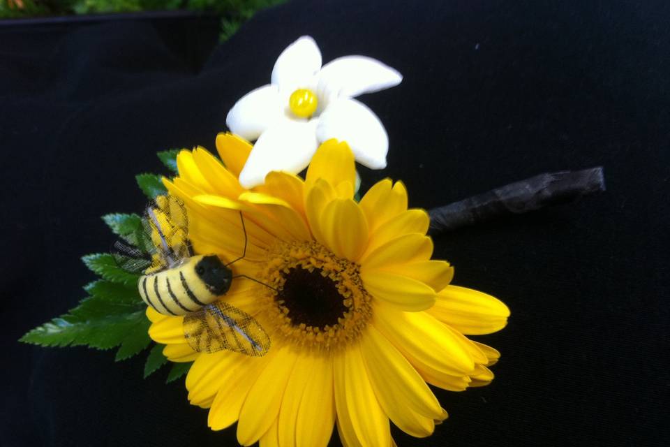 Groom's boutonniere with yellow gerbera daisy, white stephanotis and bumble bee