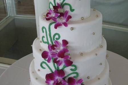 tired wedding cake with buttercream and piping with fresh tropical flowers