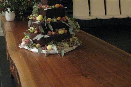 tiered wedding cake with a chocolate glaze and sugar dusted fresh fruit
