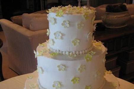 tiered wedding cake with buttercream icing and yellow sugar flowers