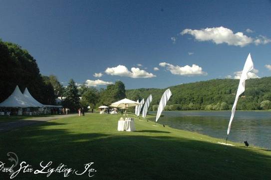 This serene, elegant outdoor wedding in Queechee, Vermont, featured uplit feather banners, tent lighting, a disco ball, and dance floor lighting all by Dark Star Lighting & Production.