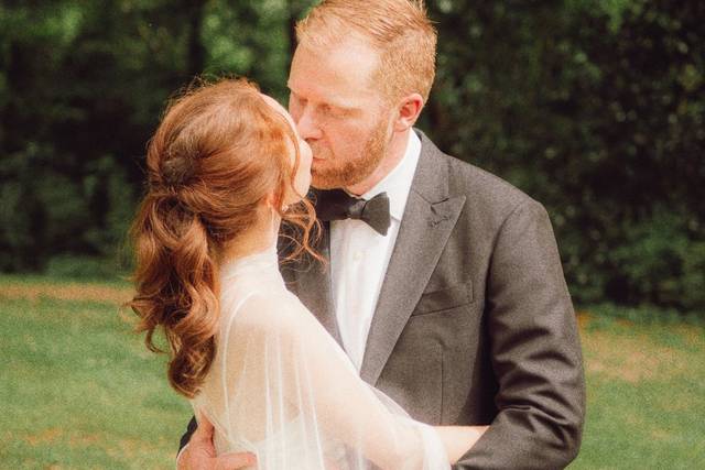 Bride and groom kissing in a g
