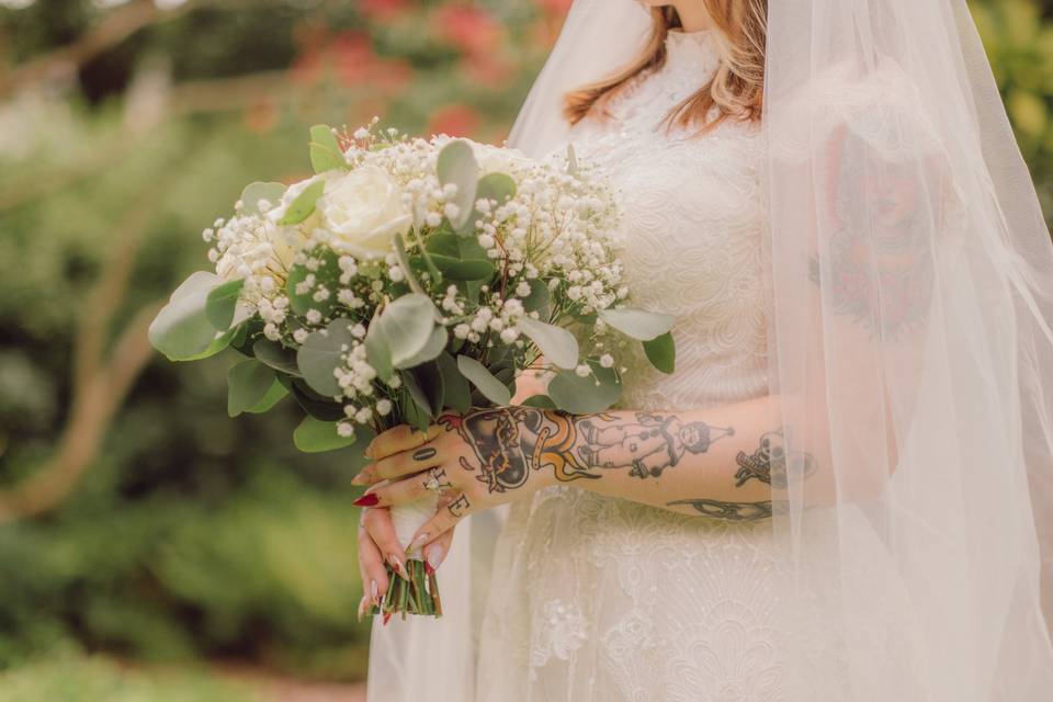 Tattooed bride holding a bouqu