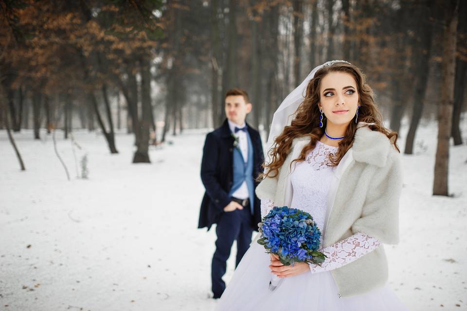 Bride and groom in the snowy woods