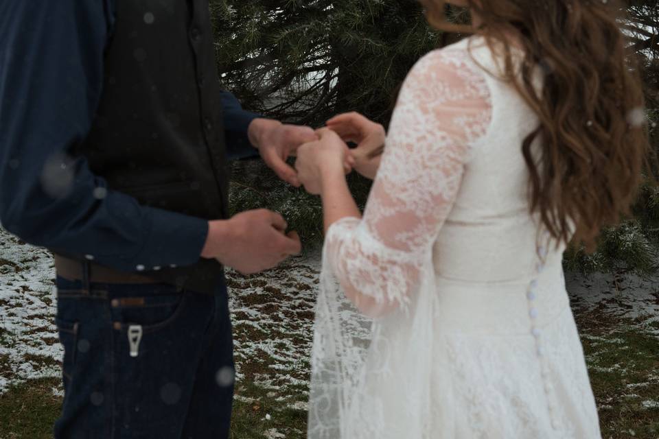 Putting wedding band on groom
