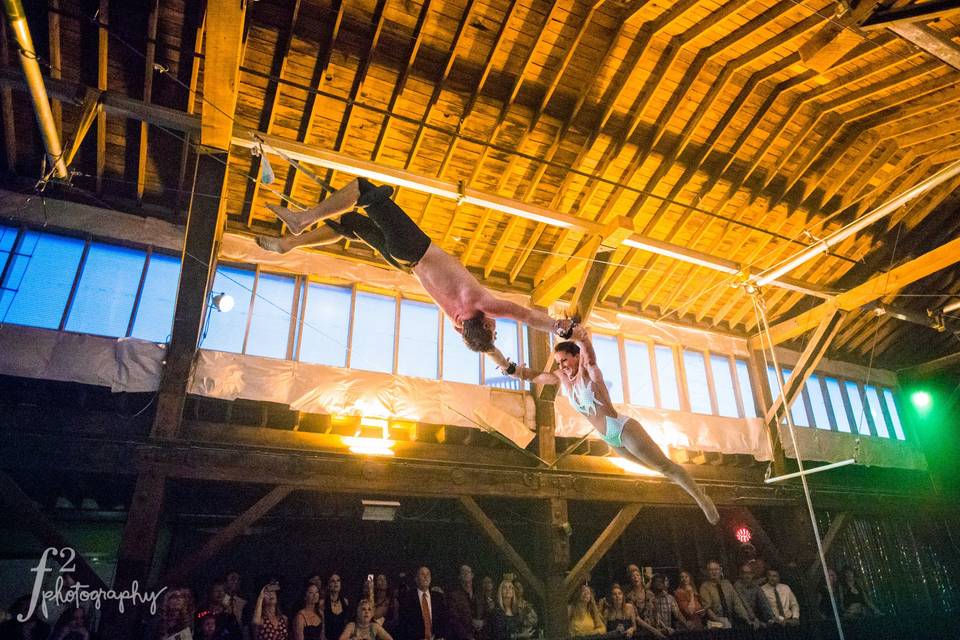 Emerald City Trapeze artists showing off their skills during a wedding. At our venue, you can hire world class performers to kick of the night with spectacular tricks! Are you ready to take the leap?