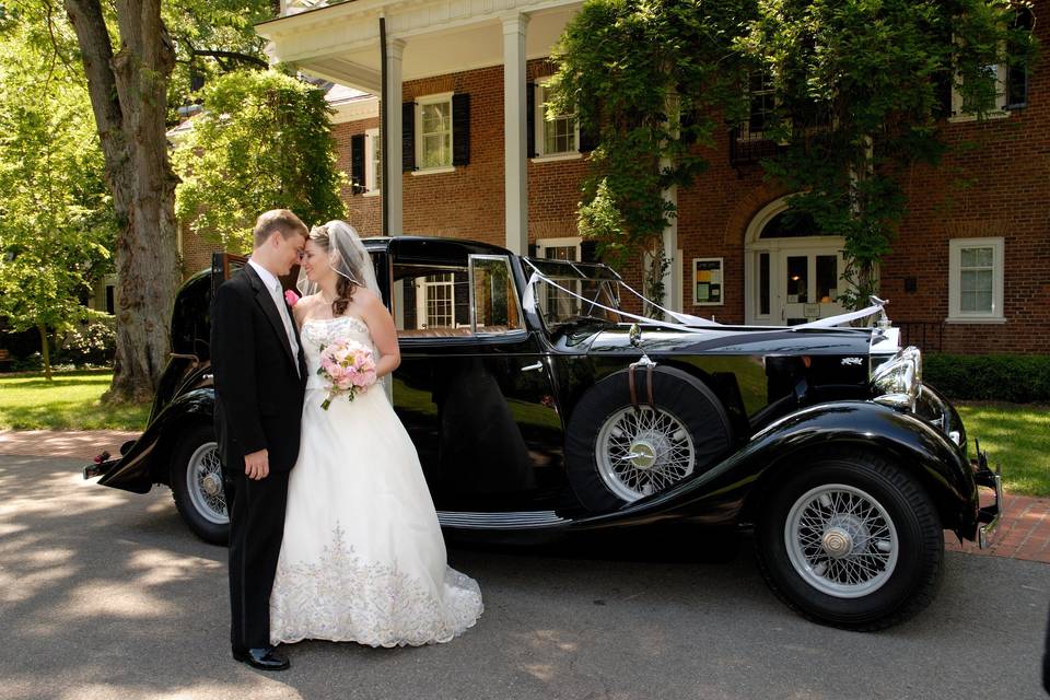 Couple in front of a vintage wedding car
