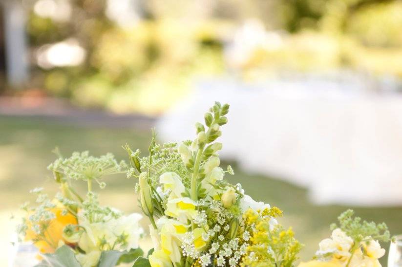 All the brightness of the blooms came to the table in yellows and natural flair with twine rope to hold the table number.