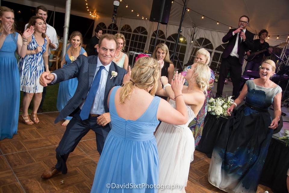 Newlyweds and guests dancing