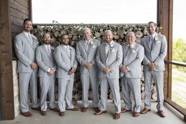 Groomsmen in front of wood pile