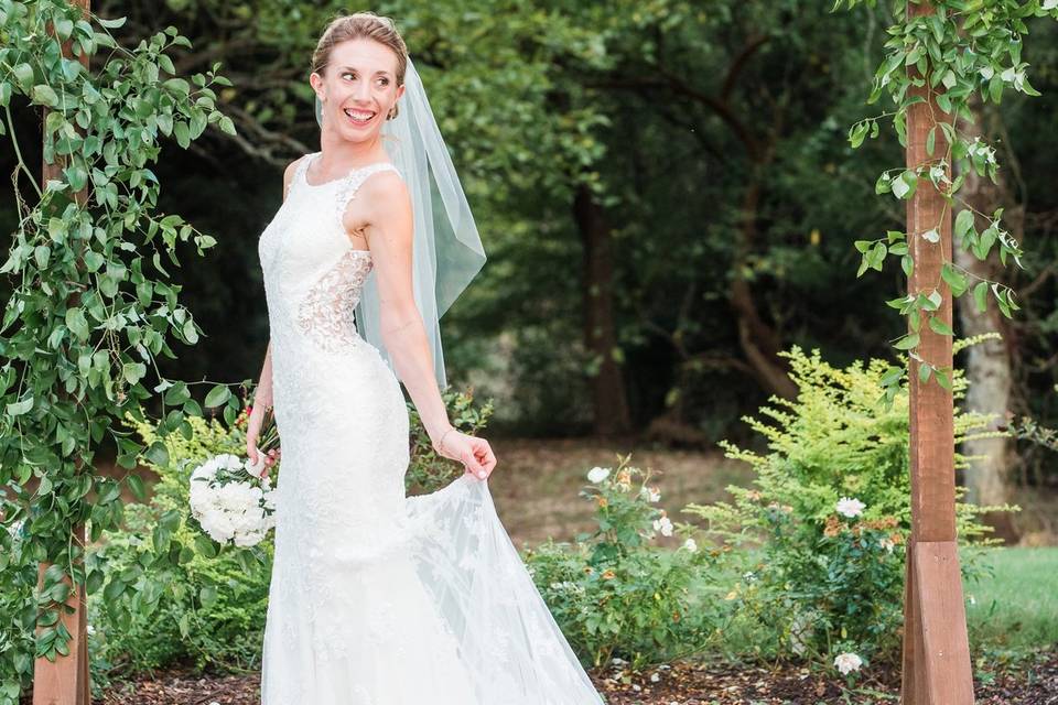 Bride smiling under arbor