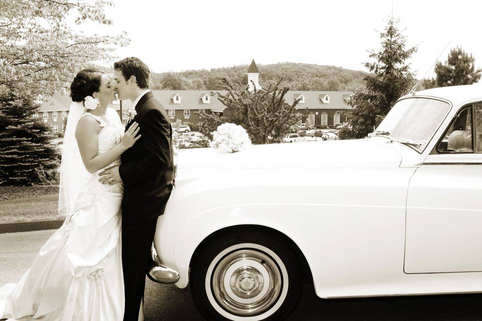 A kiss in front of a vintage vehicle