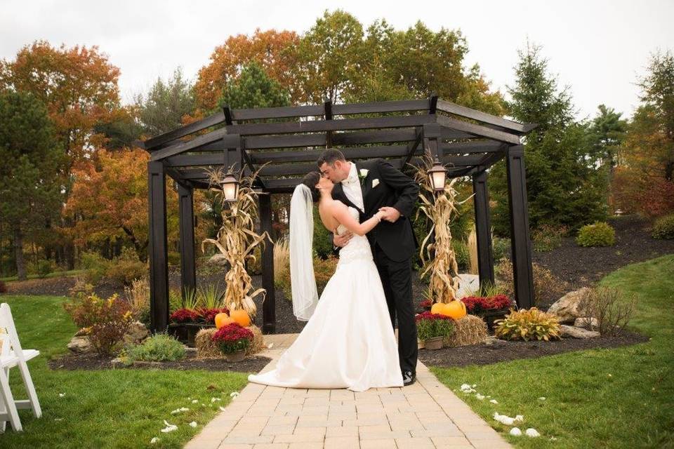 Couple kisses in front of gazebo