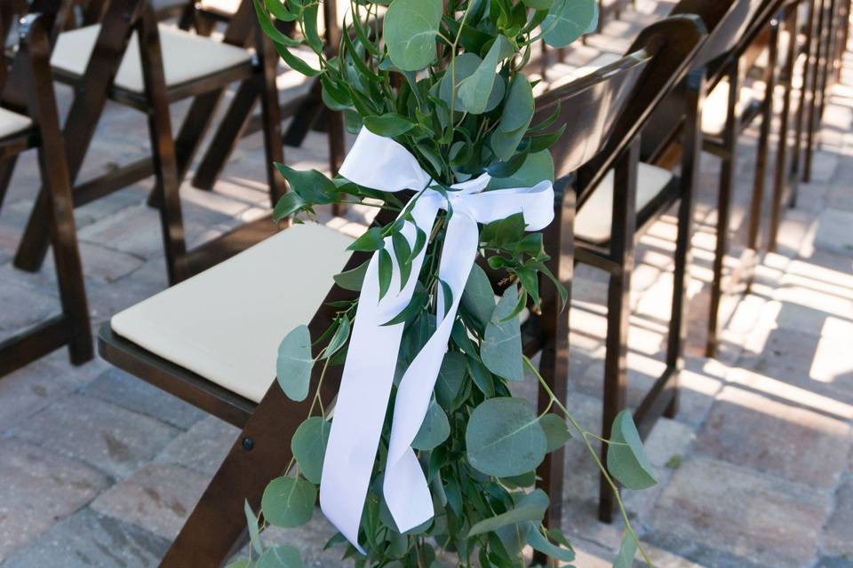 Greenery on aisle chairs