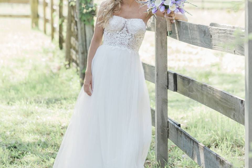 Bride leaning on a fence