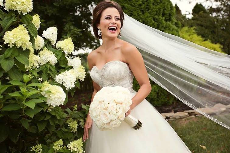 Bride smiles as her veil flows with the wind