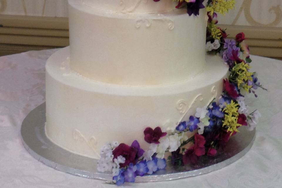 Floral wedding cake with figurines of the newlyweds