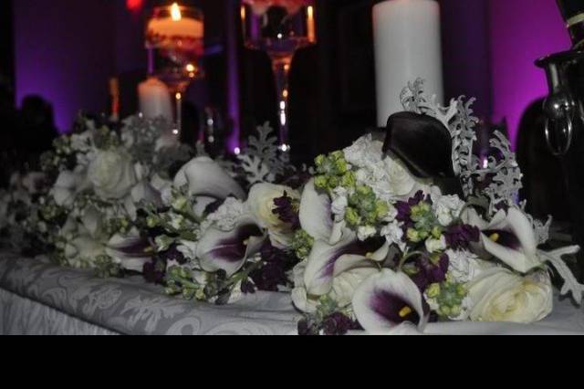tablescape using bridesmaid bouquets and floating candles in towering glassware with white cylinder candles