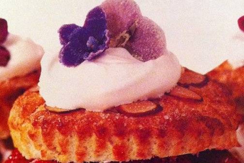 individual cookie cake with fresh whipped cream and fresh strawberries with sugared flower