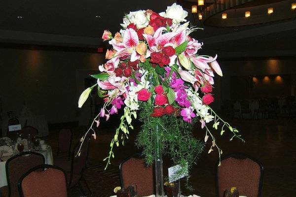 Reception tables with tall glass towers spilling over with flowers add festivity to your party!