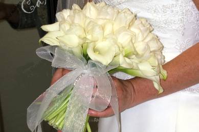 The elegance of same/kind flowers surrounded by mini-callas make a sophisticated statement. This beauty is white tulips. Wrap the stems in rhinestones for a special keepsake forever!