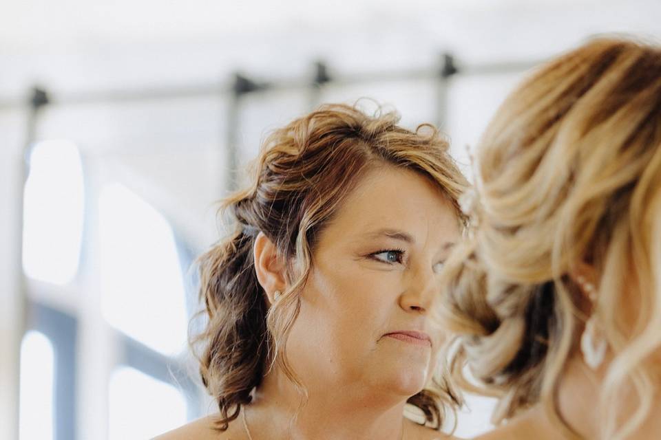 A mom putting on bride's dress