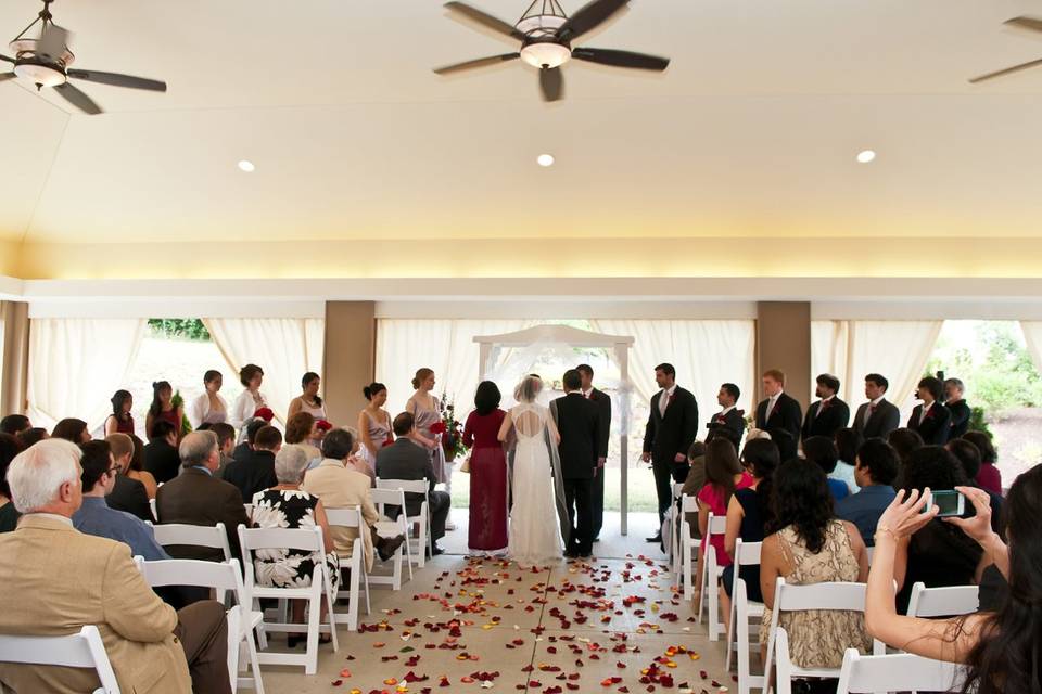 Being escorted by both parents down the rose petal lined aisle in front of family and friends on our outdoor patio.