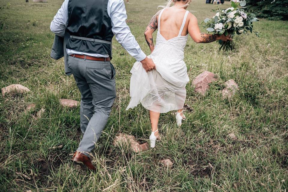 Groom holding brides dress