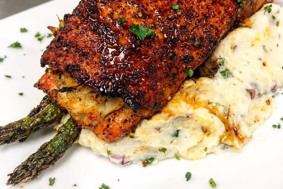 rosemary and asparagus stuffed wild caught salmon on a bed of roasted garlic mashed red potatoes