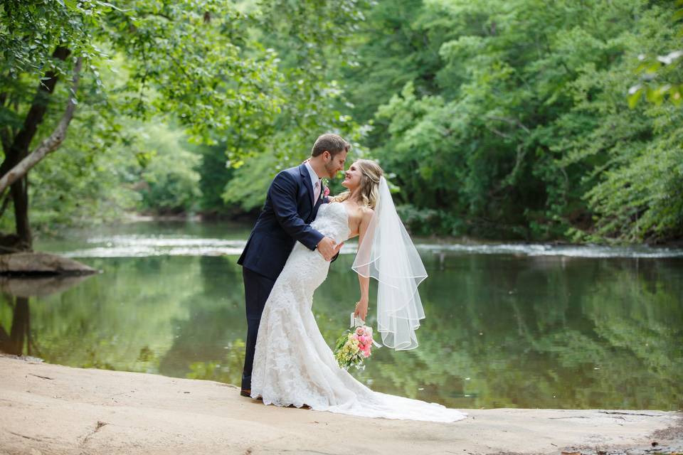Groom holding his bride by the river