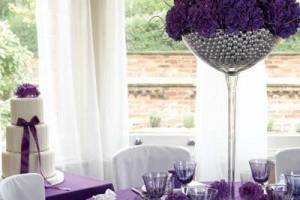 Purple mums in a beaded glass stem vase