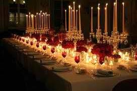 A Night in Regency England. Designed for a themed dinner party in Highland Park. Large candelabras with crystals in teardrop style, accented with small arrangements of royal roses. Tapered candles on high with votive candles set low, align the length of the table to illuminate the plates for the meal. No current lighting used, to create an authentic setting of the period.