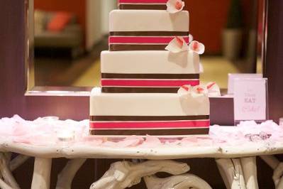 This 4-tier cake has 3 layers of coordinating ribbon to match the color scheme, as well as hand made sugar flowers.Photo credit: Alli McWhinney Photography
