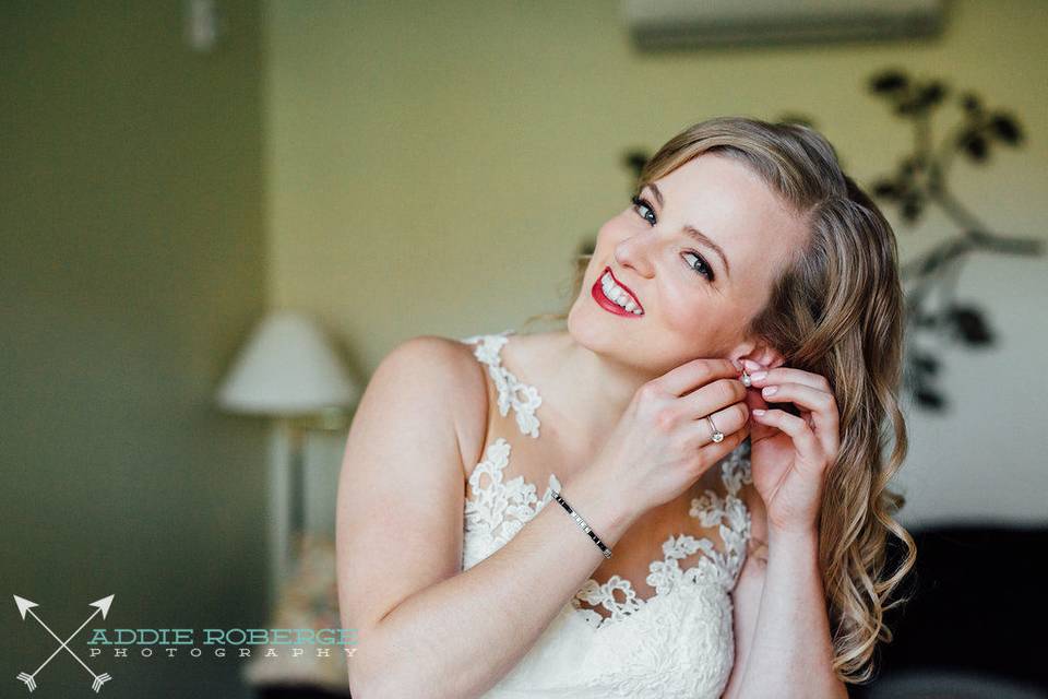 Bride putting earrings on