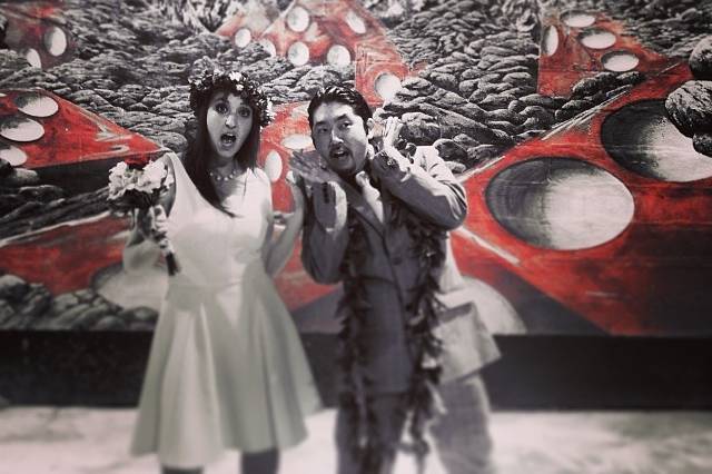 Bride and groom in front of a mural