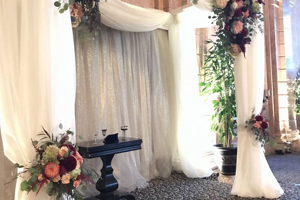 Chuppah of sheer fabric and Hayden flowers gathered