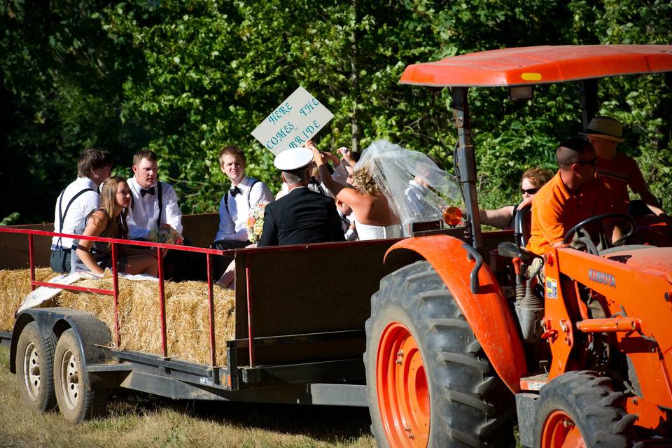 Newlyweds and their guests on a hay tractor