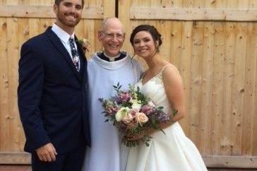 Lovely newlyweds with the officiant